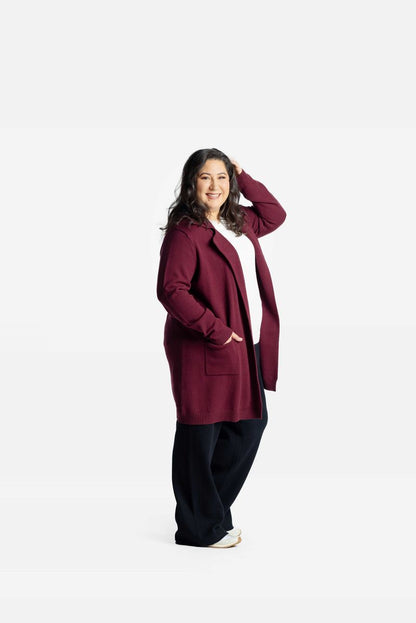 Model wearing a solid bordeaux Laura lapel open cardigan with front pockets on a white background