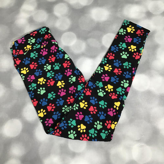 Flat lay of LuLaRoe leggings in black with multicolor paw print design in rainbow shades, yoga waistband, and ankle-length fit