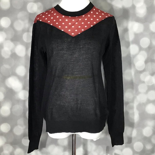 LuLaRoe Lizzy sweater in black with red mesh polka dot yoke, lightweight hacci fabric, ribbed cuffs, and polished boutique style on a mannequin against a blurred background