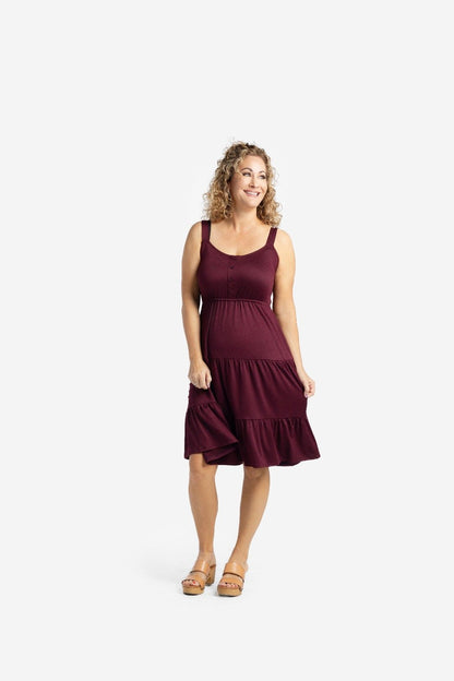 Woman modeling the LuLaRoe Amanda Dress in Solid Deep Plum, featuring a rich plum wine-colored sleeveless tiered midi silhouette with a relaxed feminine fit photographed against a light neutral studio background.