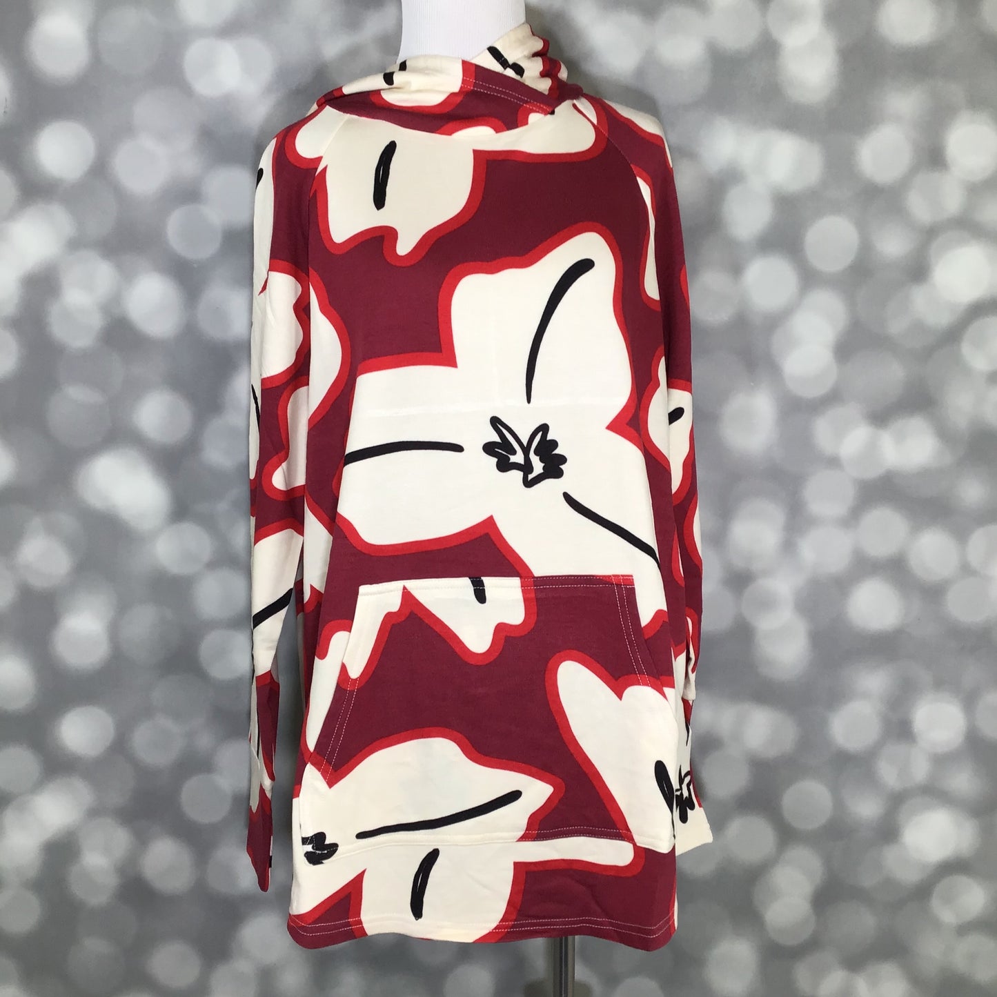 LuLaRoe Amber Hoodie in Burgundy Bloom Graphic with oversized ivory floral print on burgundy background, hood and kangaroo pocket, front view on a mannequin against a blurred background