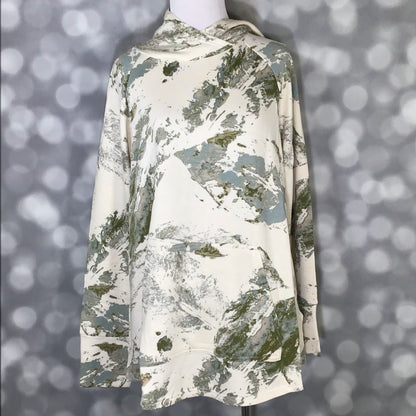 LuLaRoe Amber Hoodie in Sage Stonewash Abstract with ivory base and soft sage green and gray abstract brush pattern, hooded neckline, and kangaroo pocket featuring relaxed fit, long sleeves, soft stretch fabric on a mannequin against a blurred gray background