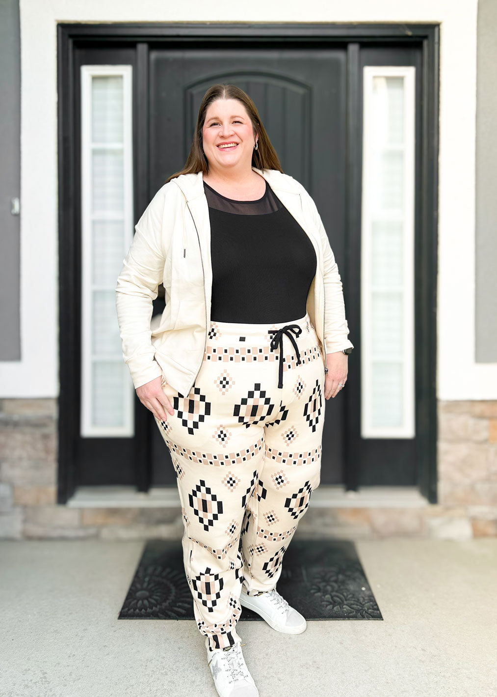 LuLaRoe Boyfriend Joggers in a cream and black geometric Aztec pattern worn by a model. Features a relaxed fit, drawstring waist, cuffed ankles, and soft knit fabric.