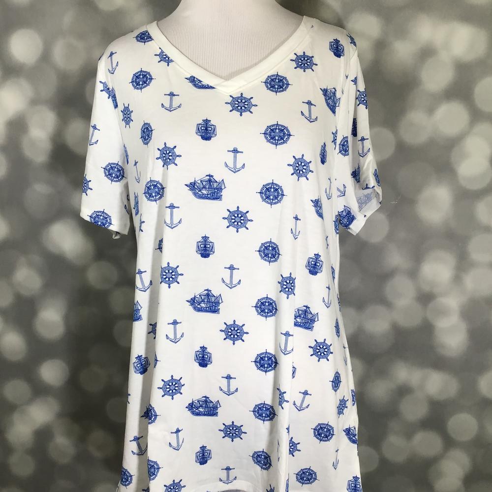 LuLaRoe Christy T featuring blue nautical sketch illustrations including anchors, sailing ships, compass roses, and ship wheels on a white background displayed on a mannequin against a silver bokeh backdrop.