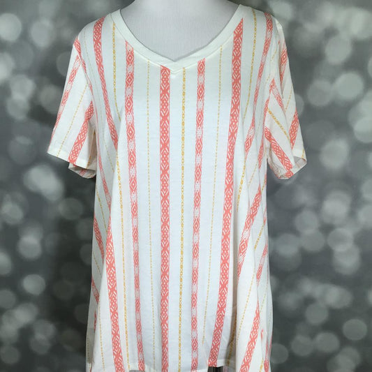 LuLaRoe Christy T featuring coral geometric vertical stripes with gold accent lines on an ivory background in a relaxed V-neck silhouette displayed on a mannequin against a silver bokeh backdrop.