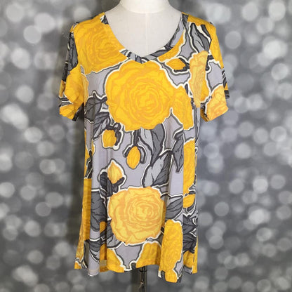 LuLaRoe Christy T in Gray, Marigold & Charcoal Rose Floral, featuring oversized marigold roses with charcoal leaves on a soft gray background, a flattering V-neckline, short sleeves and a relaxed fit.