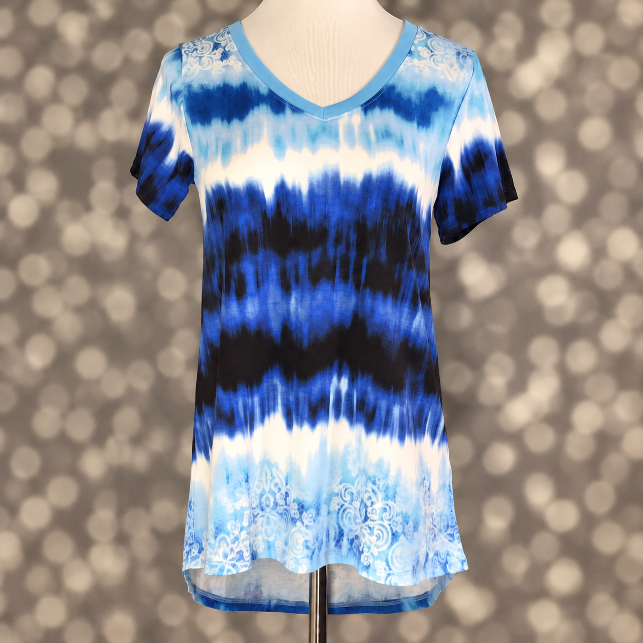 LuLaRoe Christy T in Sky Blue, Cobalt & Navy Tie-Dye Damask, featuring layered sky blue, cobalt, navy and ivory tie-dye with ornate damask accents, a flattering V-neckline, short sleeves and a relaxed fit.