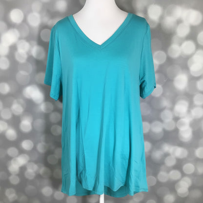 LuLaRoe Christy T in Solid Aqua Lagoon featuring a bright aqua blue color with a relaxed V-neck silhouette displayed on a mannequin against a silver bokeh background.