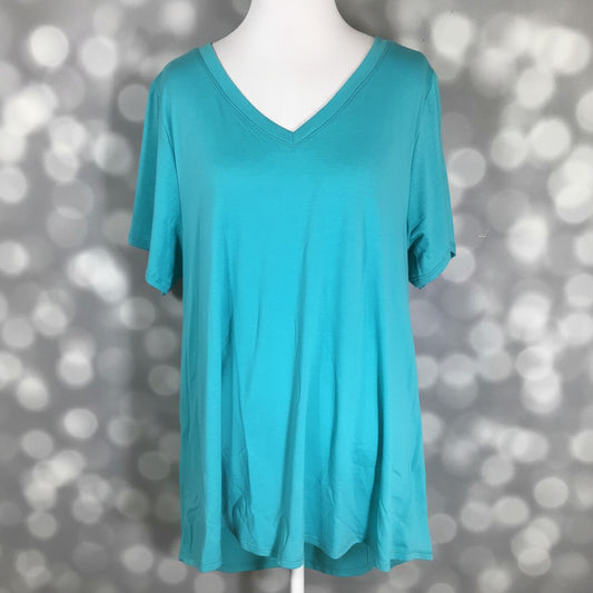 LuLaRoe Christy T in Solid Aqua Lagoon featuring a bright aqua blue color with a relaxed V-neck silhouette displayed on a mannequin against a silver bokeh background.