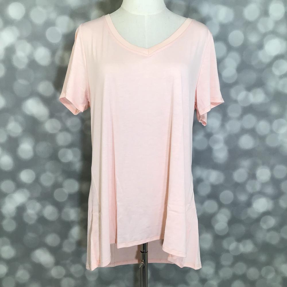 LuLaRoe Christy T in soft blush pink featuring a relaxed V-neck swing silhouette displayed on a mannequin against a silver bokeh background.