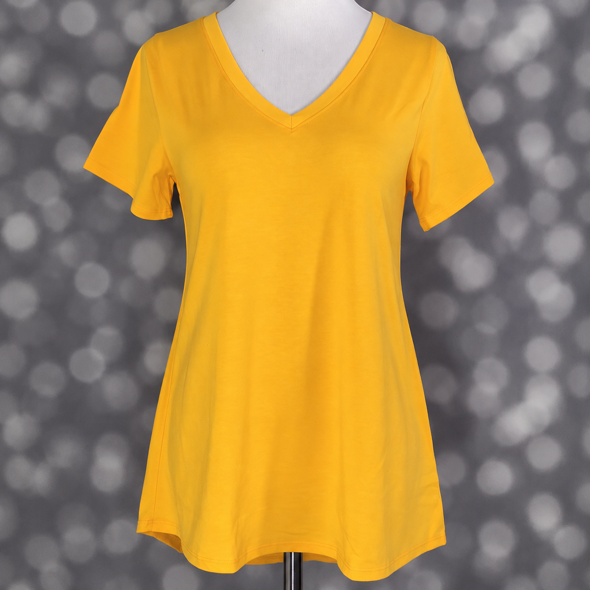 LuLaRoe Christy T in Solid Marigold Yellow, featuring a rich golden marigold-yellow color, a flattering V-neckline, short sleeves and a relaxed fit.