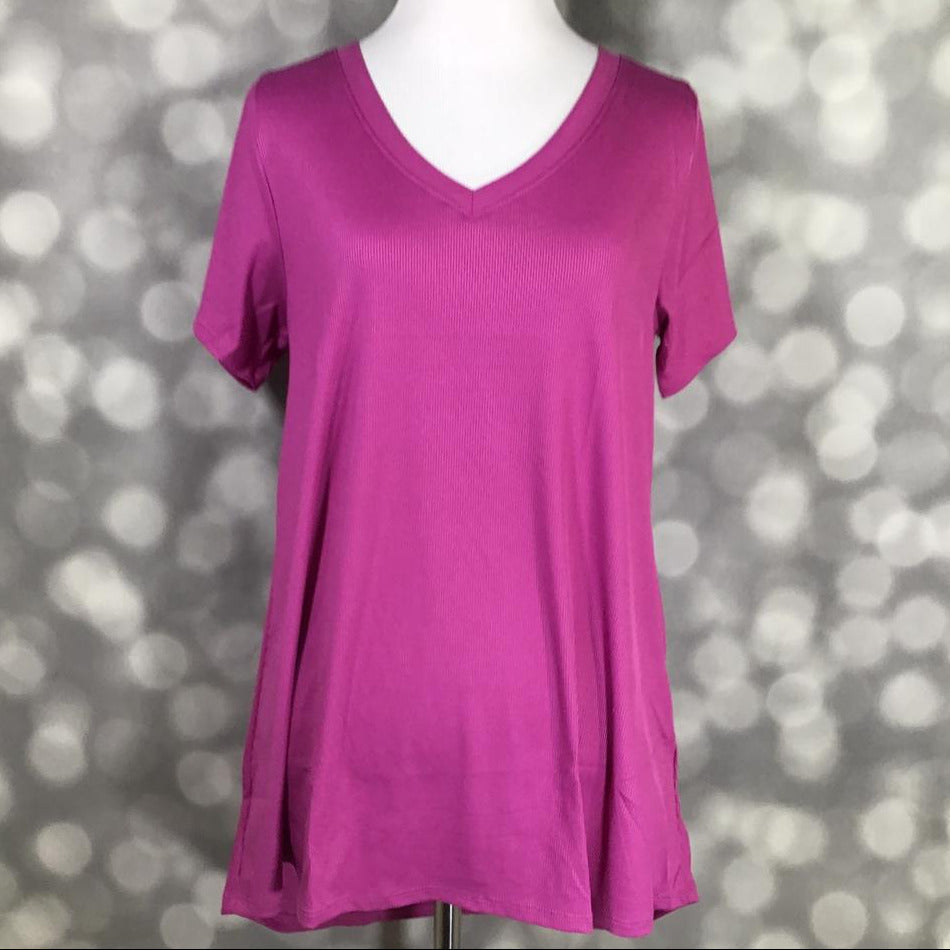 LuLaRoe Christy T in solid orchid magenta featuring a relaxed V-neck swing silhouette displayed on a mannequin against a silver bokeh background.