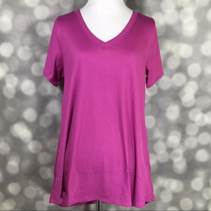 LuLaRoe Christy T in solid orchid magenta featuring a relaxed V-neck swing silhouette displayed on a mannequin against a silver bokeh background.