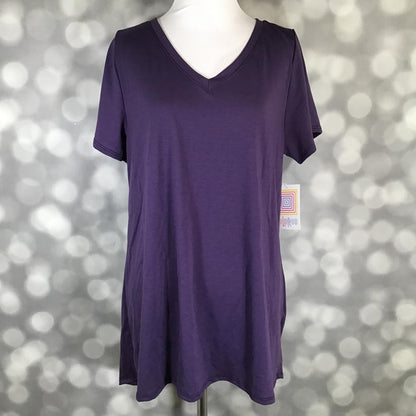 Solid deep royal plum purple LuLaRoe Christy T swing top with short sleeves and V-neckline displayed on a mannequin against a silver bokeh background.