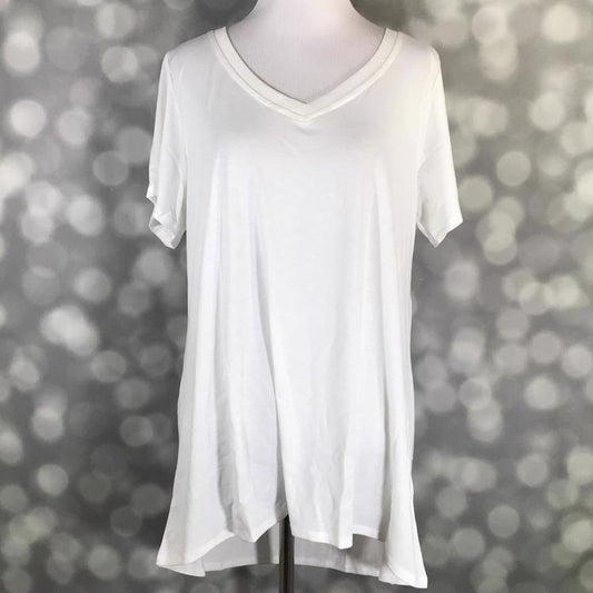 Solid white LuLaRoe Christy T swing top with short sleeves and V-neckline displayed on a mannequin against a silver bokeh background.