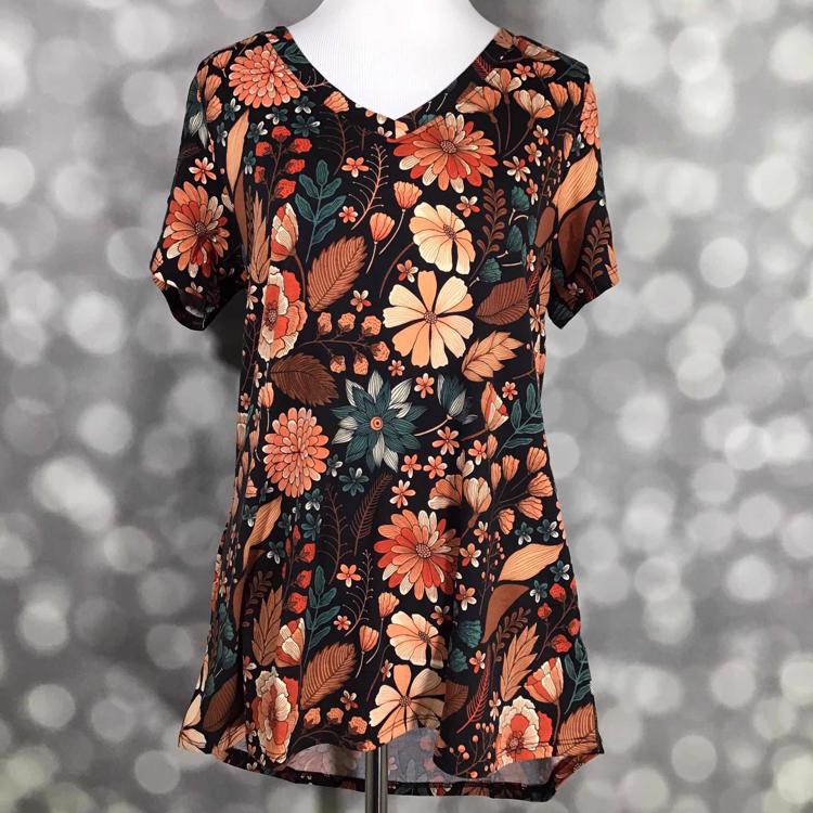 LuLaRoe Christy Tee featuring a black background with rust orange, terracotta, peach, cream, teal, and copper floral botanical print. Women's relaxed fit V-neck short sleeve top with detailed flowers, leaves, and vintage-inspired garden pattern.
