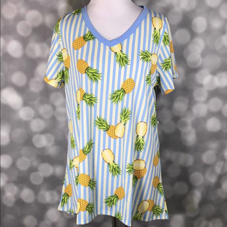 LuLaRoe Christy tee with blue and white vertical stripes and yellow pineapple print, v-neckline, short sleeves, relaxed flowy fit, displayed on mannequin
