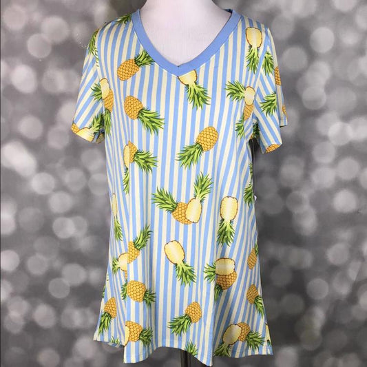 LuLaRoe Christy tee with blue and white vertical stripes and yellow pineapple print, v-neckline, short sleeves, relaxed flowy fit, displayed on mannequin