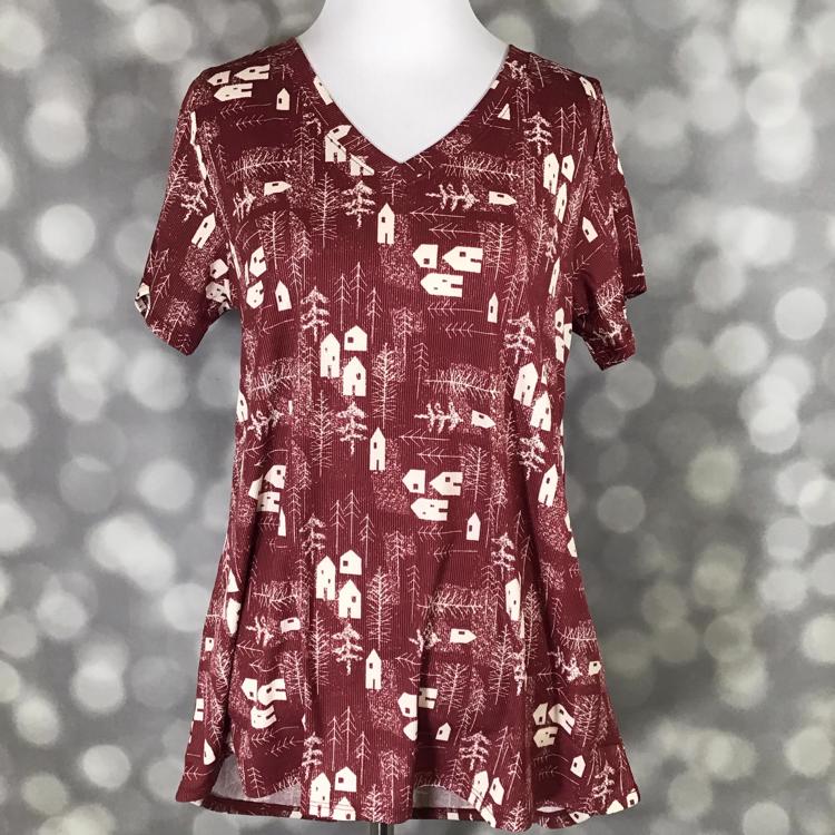 LuLaRoe Christy tee in burgundy with white cabin and tree print, short sleeves, v-neckline, relaxed flowy fit, displayed on mannequin