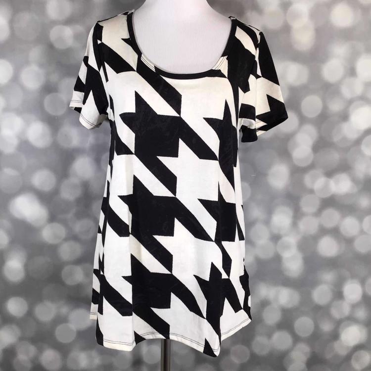 Front view of LuLaRoe Classic T on mannequin showcasing oversized black and white houndstooth pattern with curved hem and short sleeves