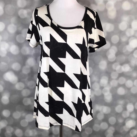 Front view of LuLaRoe Classic T on mannequin showcasing oversized black and white houndstooth pattern with curved hem and short sleeves