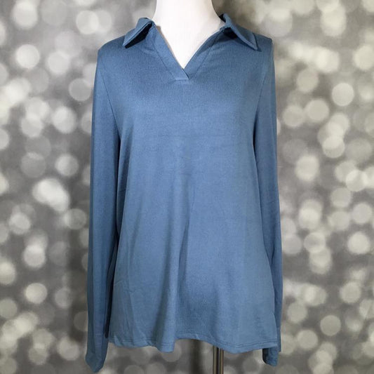 LuLaRoe Courtney long sleeve collared top in solid coronet blue brushed Hacci knit displayed on a mannequin. Soft, textured fabric with a relaxed fit and V-neckline.