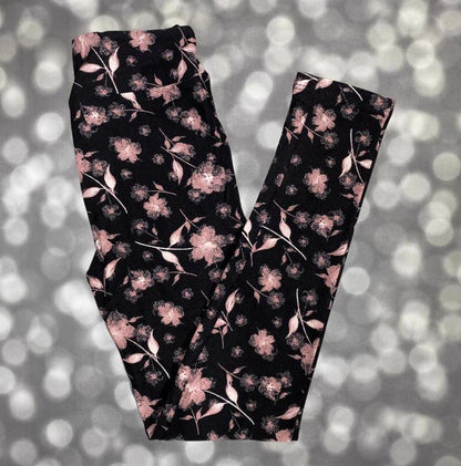 LuLaRoe leggings with soft dusty pink flowers and leaves scattered across a rich black background