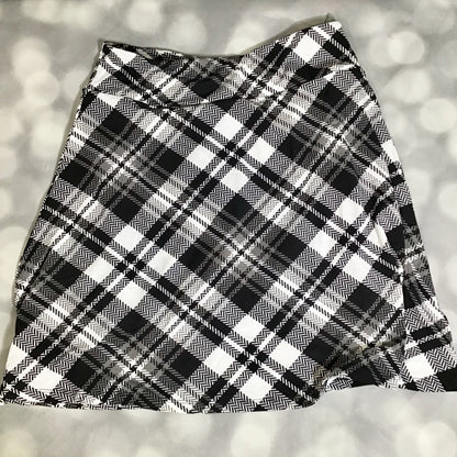 LuLaRoe Eileen skort in black and ivory plaid pattern featuring a classic tartan-style design with a flared silhouette and built-in shorts on a light gray background