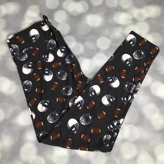 LuLaRoe leggings with brown footballs and black and white helmet print on a charcoal gray background
