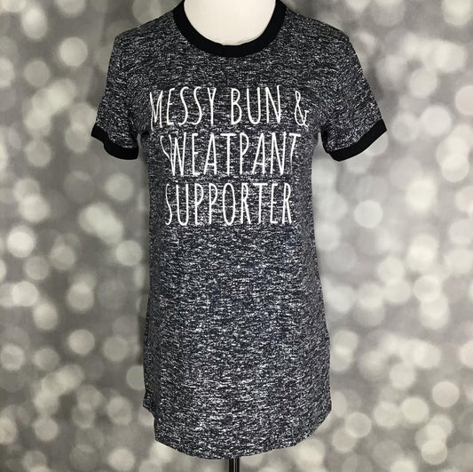 LuLaRoe heathered black graphic tee with “Messy Bun & Sweatpant Supporter” slogan in white lettering on a blurred background