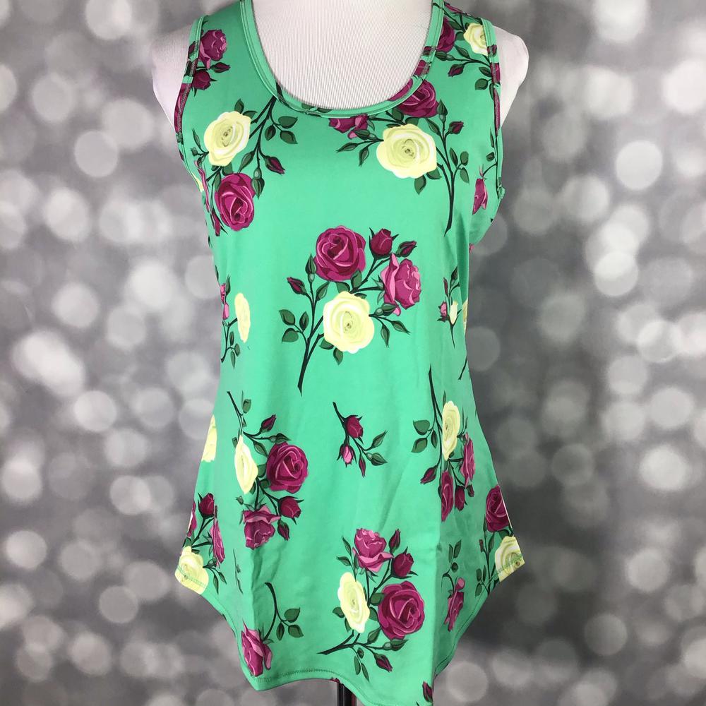 LuLaRoe sleeveless tank top with emerald green background and magenta and cream rose floral print, featuring a relaxed fit and curved hem displayed on a mannequin against a blurred background
