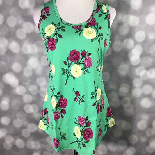 LuLaRoe sleeveless tank top with emerald green background and magenta and cream rose floral print, featuring a relaxed fit and curved hem displayed on a mannequin against a blurred background
