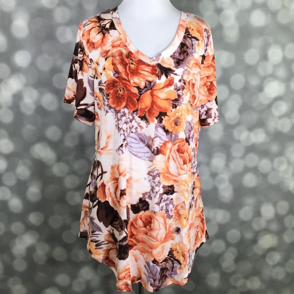 LuLaRoe Iris Tee in Autumn Rose Garden featuring peach, apricot, terracotta, and lavender floral blooms on an ivory background with a rounded v-neckline, relaxed sleeves, and tunic-length silhouette.