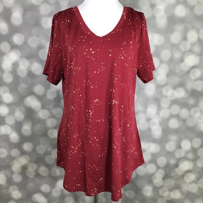 LuLaRoe Iris Tee in Crimson Stardust featuring a rich crimson red background with ivory speckled abstract star-like accents, relaxed tunic silhouette, rounded v-neck, short sleeves, and curved shirttail hem.