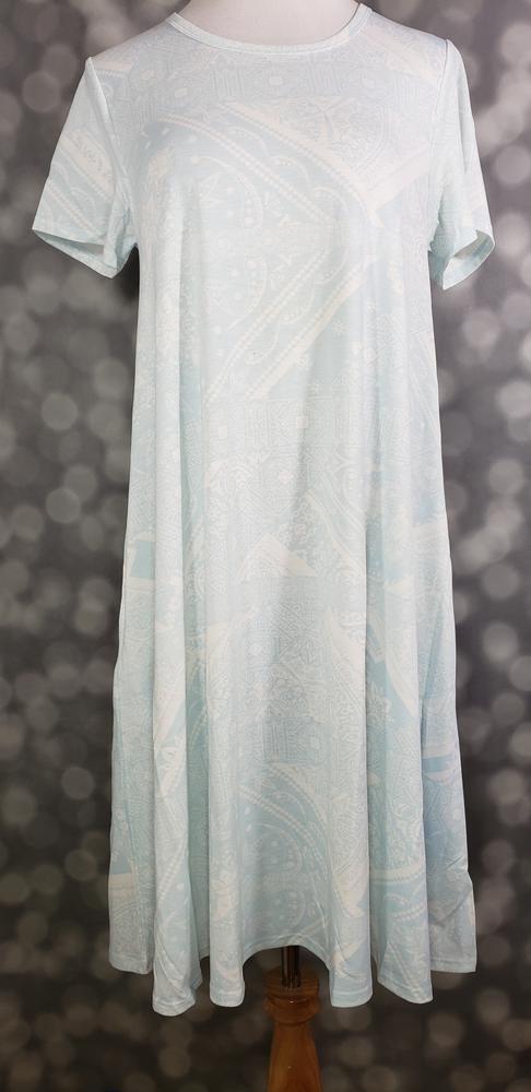Front view of LuLaRoe Jessie dress on mannequin featuring light pastel blue fabric with subtle white paisley design and flowing swing fit against a blurred background