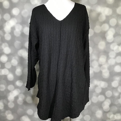 LuLaRoe Jolene V-neck tunic in solid black bubble jacquard fabric long sleeve relaxed-fit tunic with high-low hem and gauze-like texture displayed on mannequin against a blurred gray background