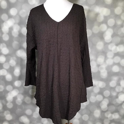 LuLaRoe Jolene V-neck tunic top in solid chocolate torte brown bubble jacquard fabric displayed on a mannequin. Long sleeve, relaxed-fit tunic with gauze-like texture and high-low hem.