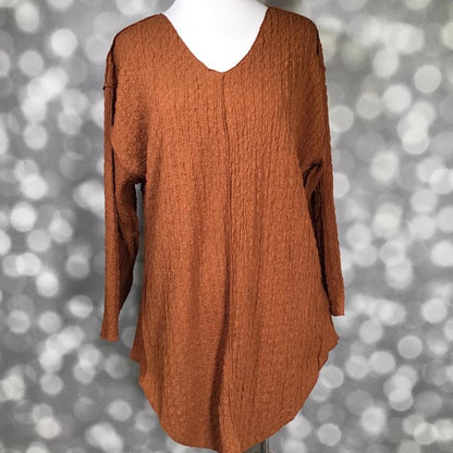 LuLaRoe Jolene V-neck tunic in solid mocha bisque brown bubble jacquard fabric, relaxed-fit long sleeve tunic with gauze-like texture and high-low hem displayed on mannequin.