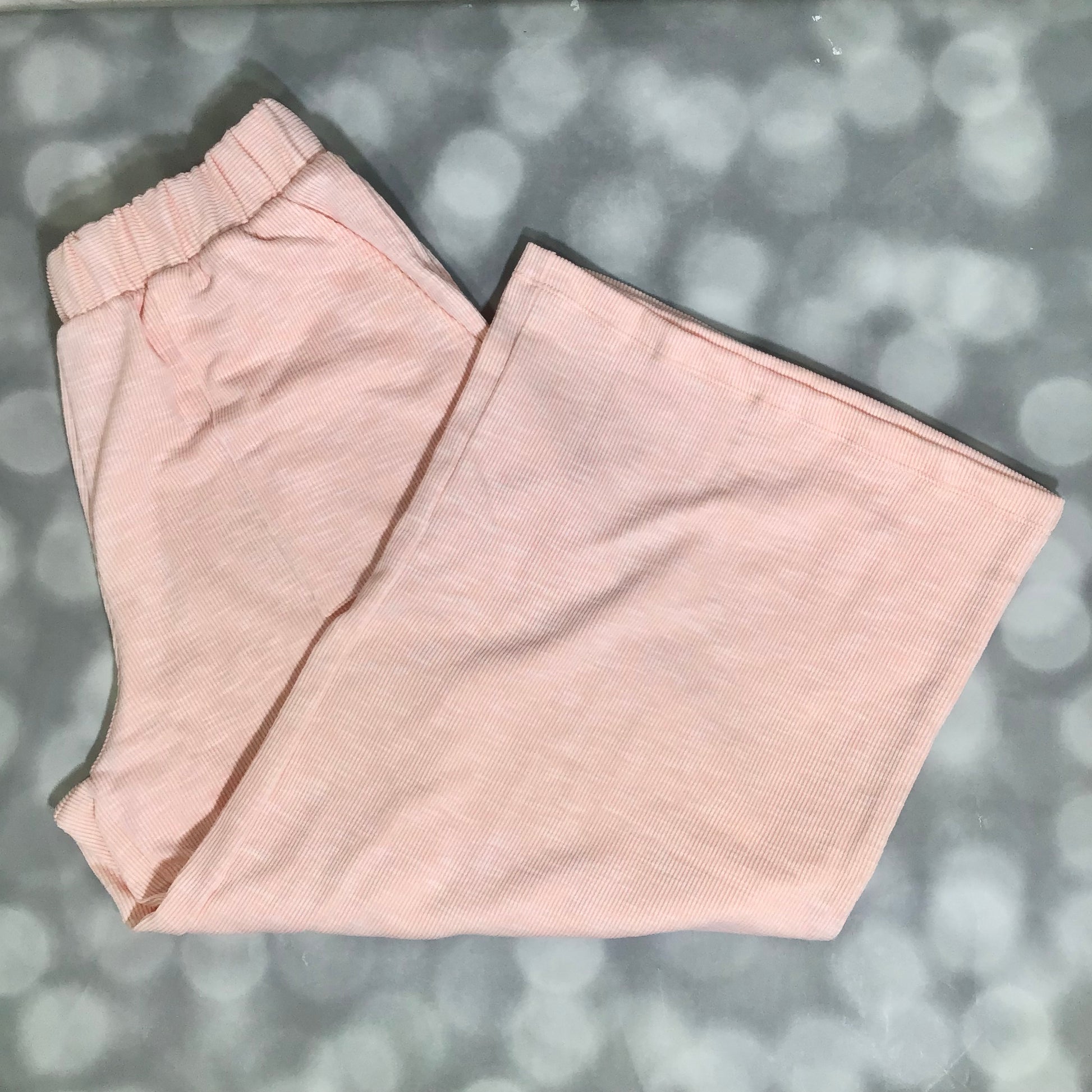 LuLaRoe Justine Pant in Solid Peach Blossom featuring a soft pastel peach solid color, relaxed wide leg silhouette, elastic waistband, comfortable pull-on women's fashion pant.