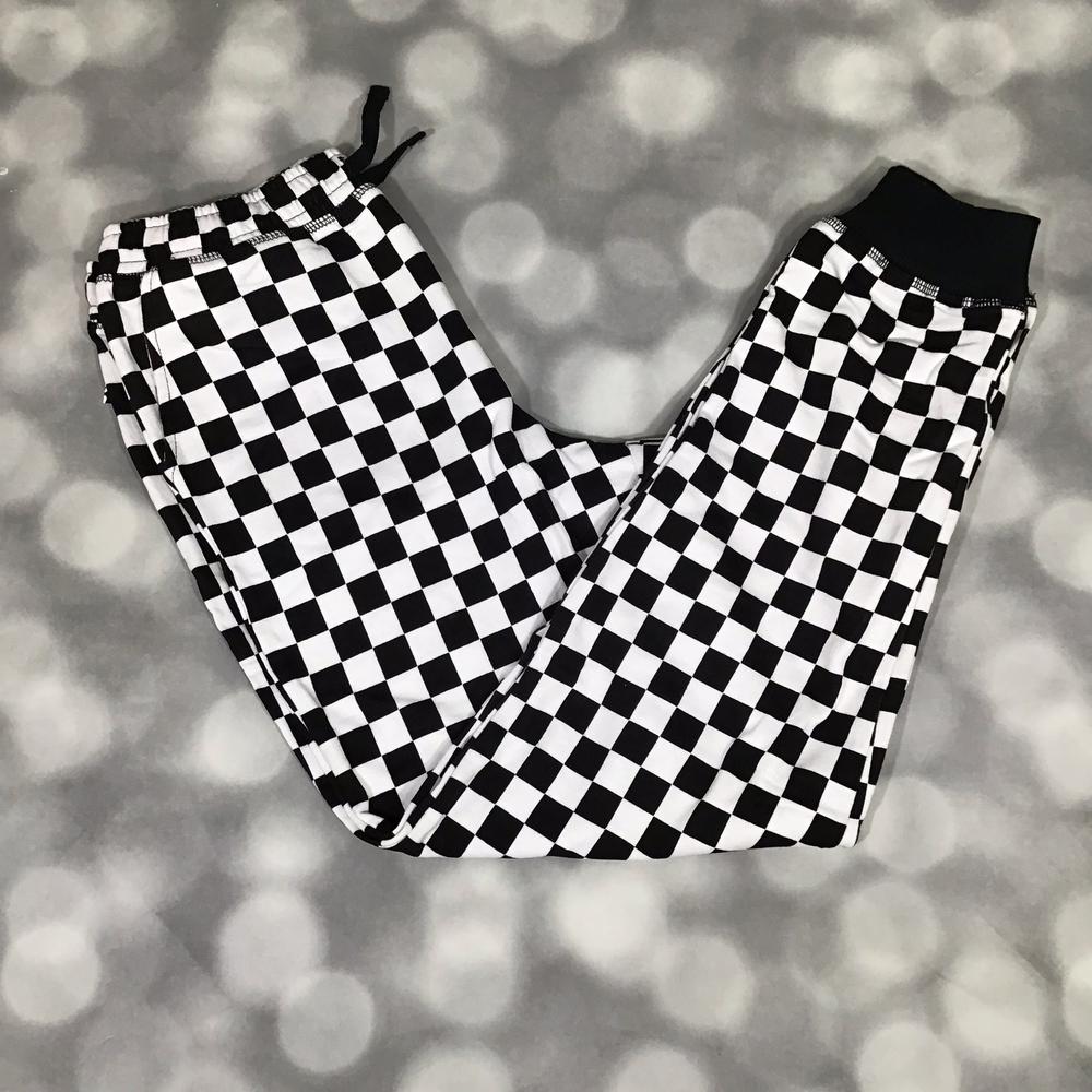 Kids Jax Joggers in bold black and white checkerboard print with ribbed cuffs on a blurred gray background