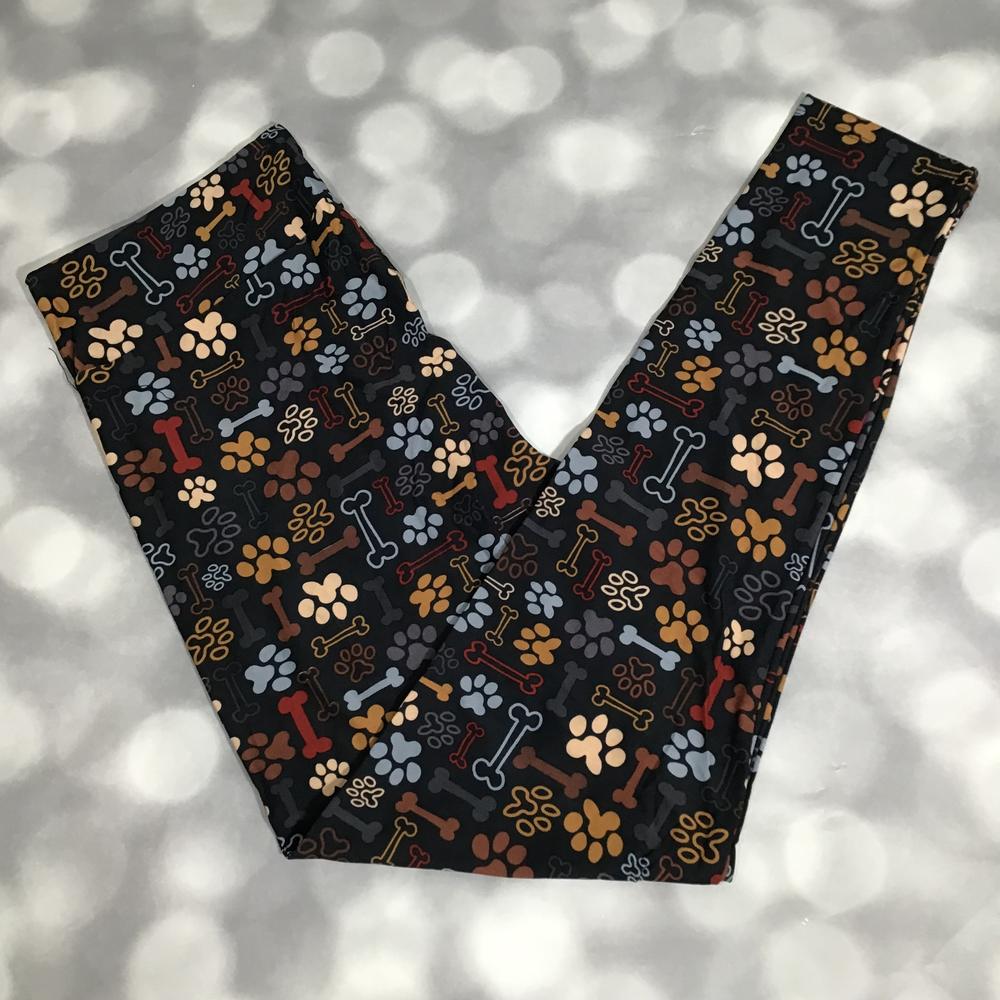 Leggings with dog bone and paw print pattern on a dark background