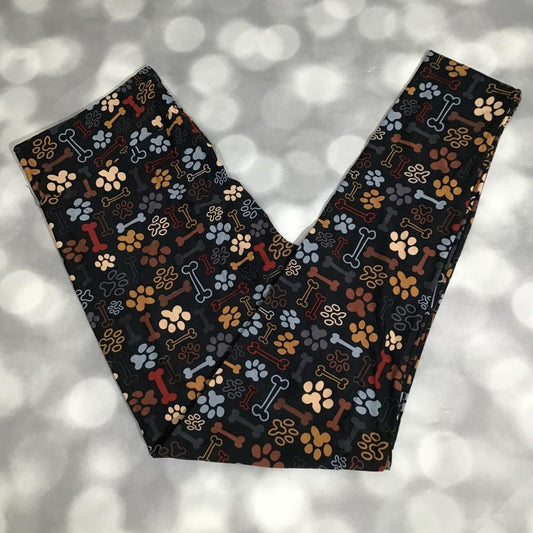 Leggings with dog bone and paw print pattern on a dark background