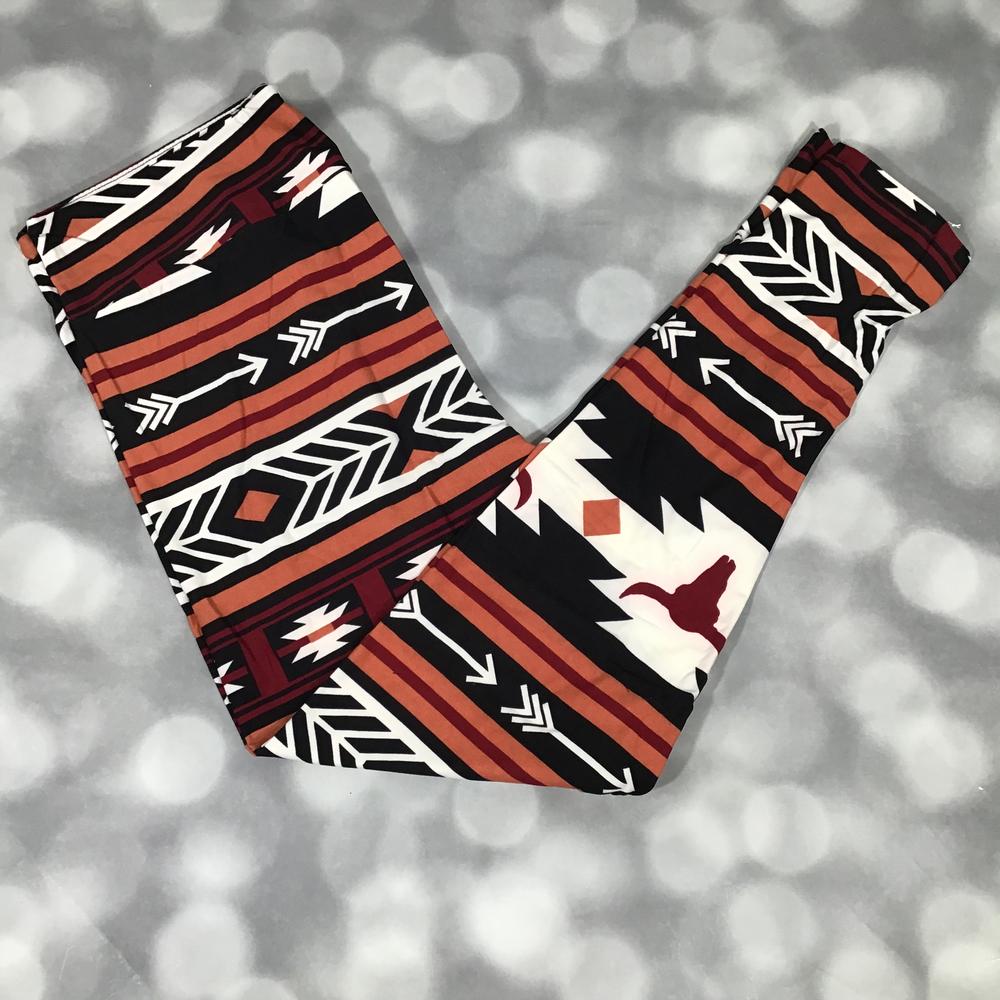 LuLaRoe leggings featuring a Southwestern tribal pattern with arrows, geometric motifs, and longhorn silhouettes in rust, burgundy, ivory, and black. Western-inspired leggings with desert colors and bold Aztec-style design perfect for casual outfits and rustic fashion on a blurred background
