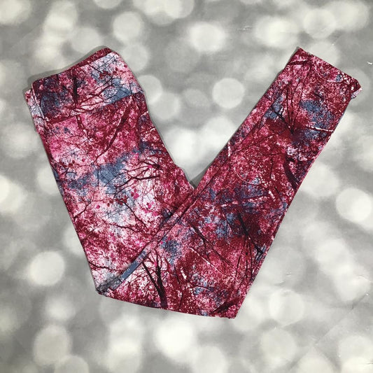 LuLaRoe leggings laid flat featuring a red and raspberry abstract tree branch silhouette print with slate blue accents on a light gray textured background