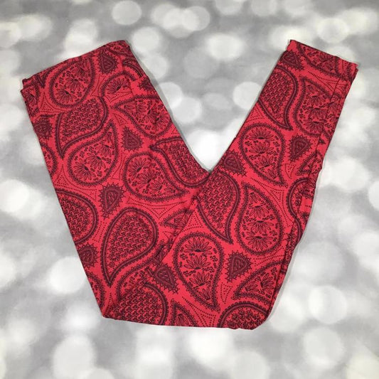 LuLaRoe leggings laid flat featuring a red background with detailed black paisley and teardrop patterns arranged in a classic all-over design.