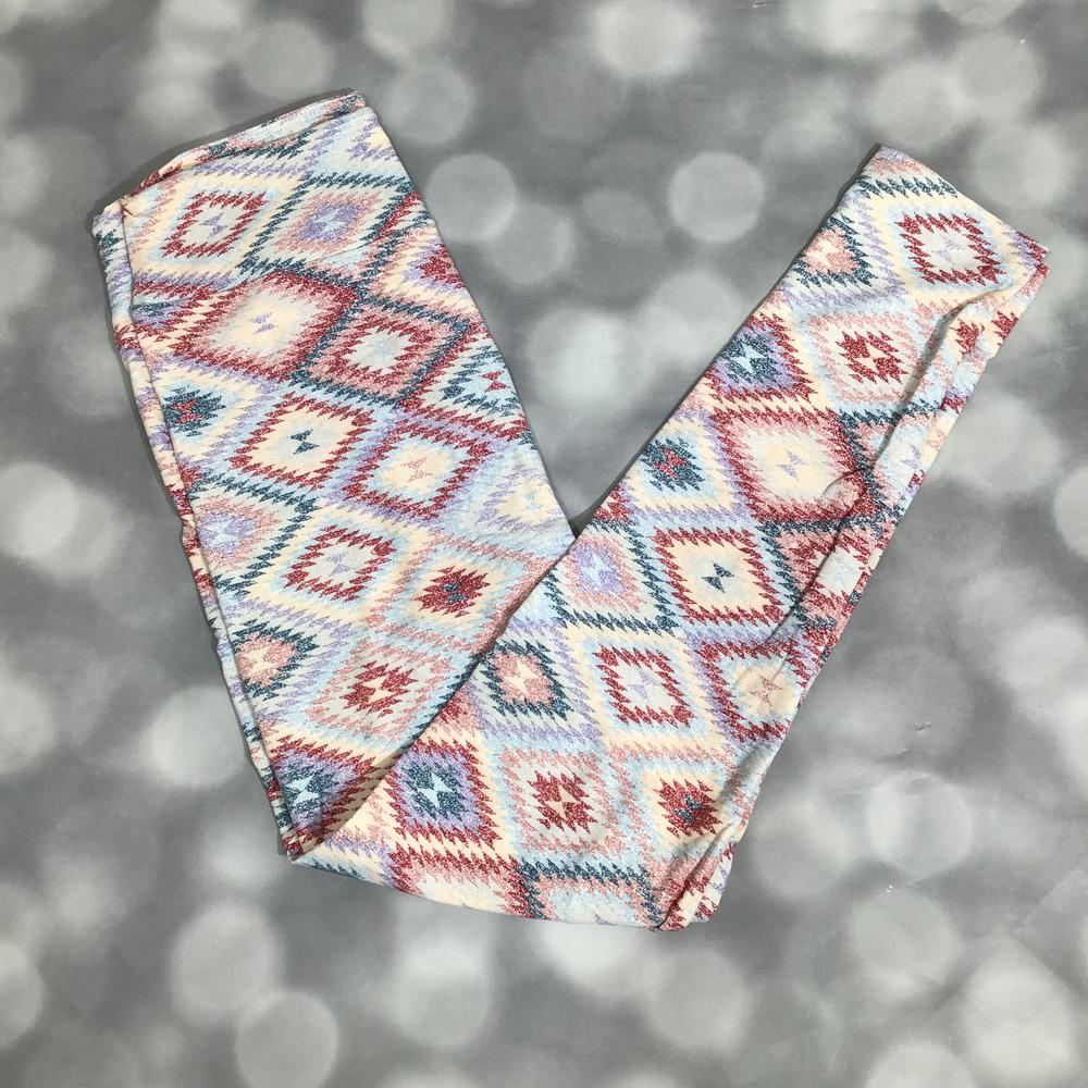 LuLaRoe leggings featuring a soft diamond-pattern print with a woven look in blush, teal, ivory, and denim blue tones, laid flat on a light gray background.