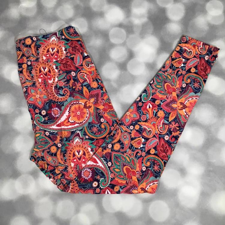 LuLaRoe leggings laid flat featuring a navy background with multicolor paisley and floral motifs in rust, coral, teal, and golden tones arranged in a detailed all-over pattern.