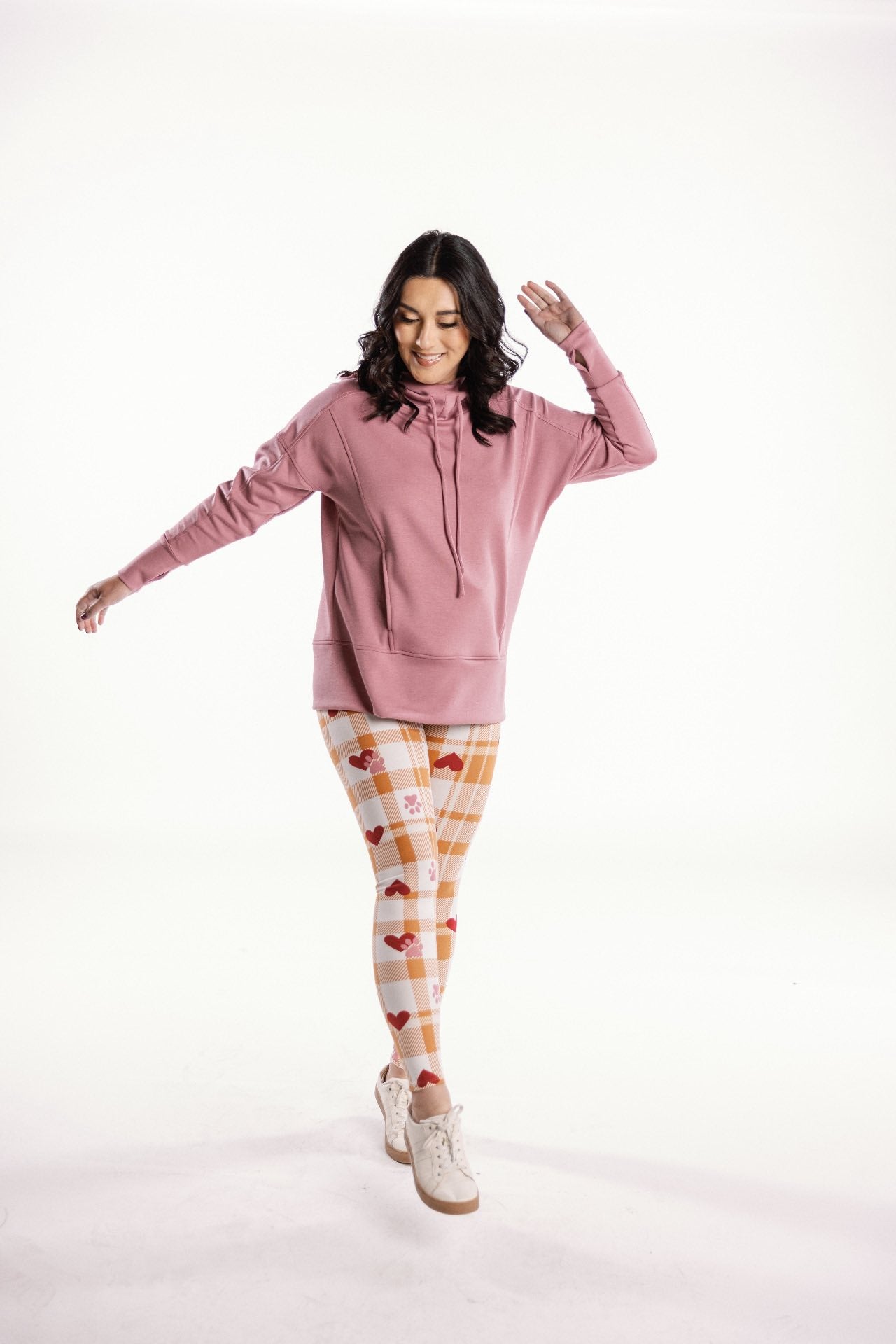 LuLaRoe leggings featuring a cream and honey gingham plaid pattern with red heart accents and small pink paw-print details, styled on model on a white background