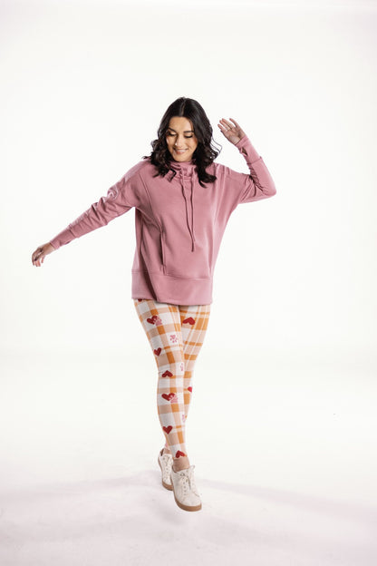 LuLaRoe leggings featuring a cream and honey gingham plaid pattern with red heart accents and small pink paw-print details, styled on model on a white background