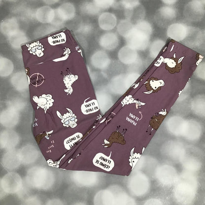 LuLaRoe leggings with a playful llama print and speech bubbles on a mauve purple background, shown in flat lay on a blurred gray background